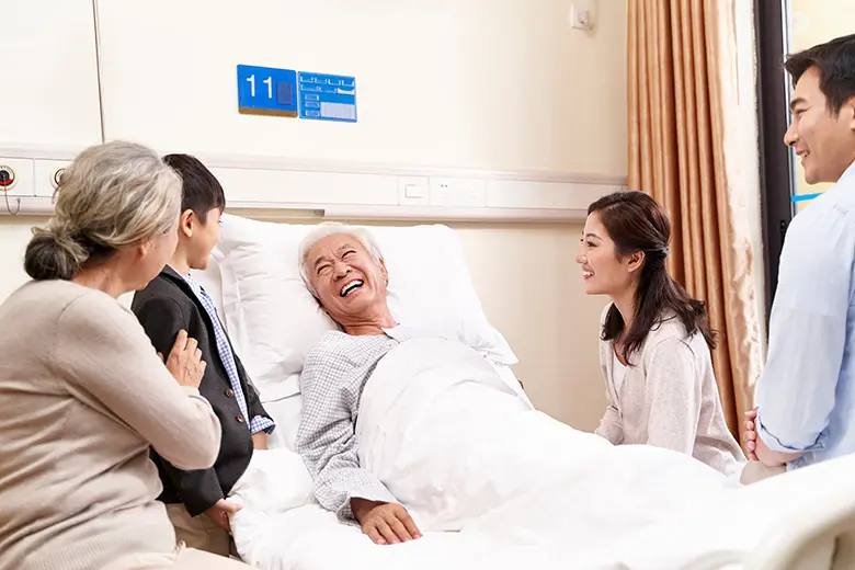 Family visiting elderly patient in hospital