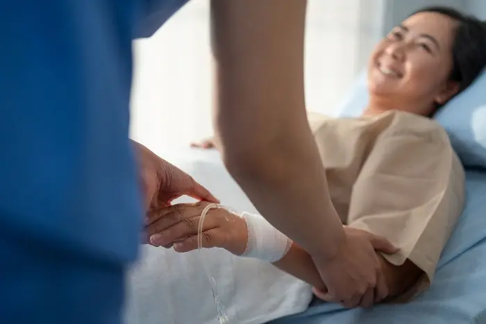 A female patient in the ward smiling at her nurse