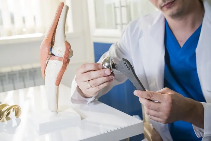 An orthopaedic surgeon holding a joint implant commonly used for joint replacement procedures