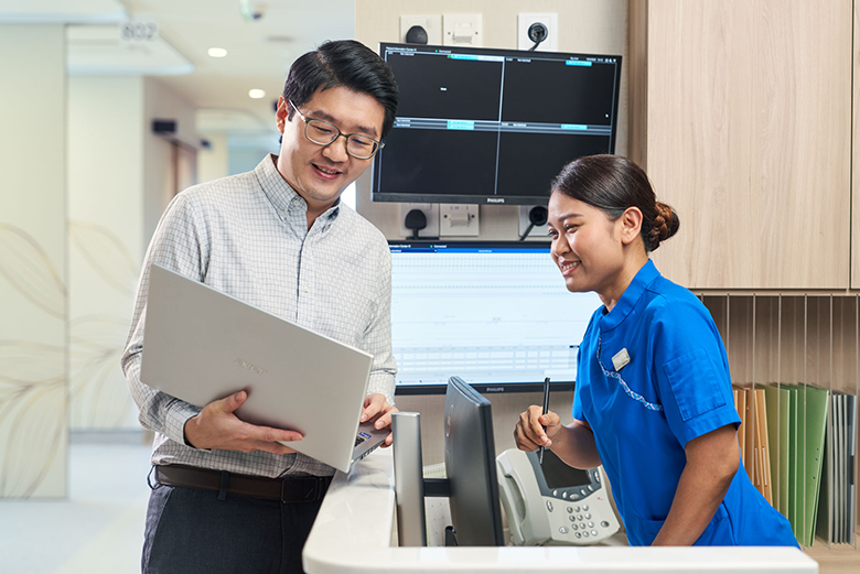 Doctor with nurse looking at laptop