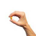 Woman’s hand holding Metagenics Concentrated Ultra Prostagen™ capsule. 