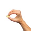 Woman’s hand holding Metagenics Metagenics OmegaGenics® Neuro Fish Oil 1000 mg softgel .