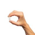 Woman’s hand holding Metagenics Arginine Plus™ tablet. 
