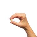 Woman’s hand holding Metagenics Black Cohosh Plus® tablet. 
