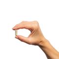 Hand holding a single Metagenics SeroSyn™ capsule. 