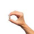 Woman’s hand holding Metagenics Cardiogenics® Intensive Care tablet.