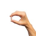 Hand holding a single Metagenics Metagenics Trancor® capsule. 
