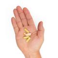 Hand holding Metagenics Immune Defense Pack supplements.