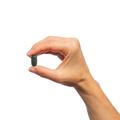 Hand holding a single Metagenics Testralin® tablet.