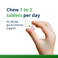 Woman’s hand holding Metagenics Metagenics UltraFlora® Kids's Probiotic tablet. 
