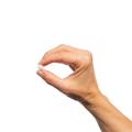 Woman’s hand holding Metagenics FolaPro® tablet.