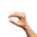 Hand holding a single Bone Builder® with Boron tablet.
