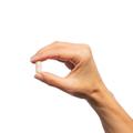 Woman’s hand holding Metagenics Metagenics Glucosamine Sulfate tablet. 