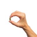 Woman’s hand holding Metagenics Echinacea Synergy™ tablet.