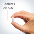 Hand holding a single tablet, highlighting a recommended dosage of three tablets per day for optimal bone health support.