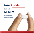 Hand holding white Metagenics magnesium tablet with instructions to take 1 tablet 3 times daily
