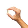 Woman’s hand holding Metagenics OmegaGenics® Fish Oil EPA-DHA 720 mg softgel. 