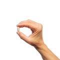 Woman’s hand holding Metagenics MyoCalm® Plus tablet.
