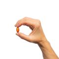 Woman’s hand holding Metagenics OmegaGenics® Algae Omega-3s softgel. 