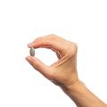 Woman’s hand holding Metagenics Exhilarin® tablet.