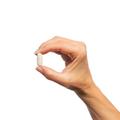 Woman’s hand holding Metagenics Alpha-Lipoic Acid 300 mg tablet. 