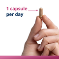 Dosage image showing one capsule of HerWellness Naturally Balanced being held between two fingers, with overlay text recommending 1 capsule per day.