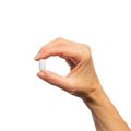 Woman’s hand holding Metagenics Metagenics Glucosamine Sulfate 750™tablet. 