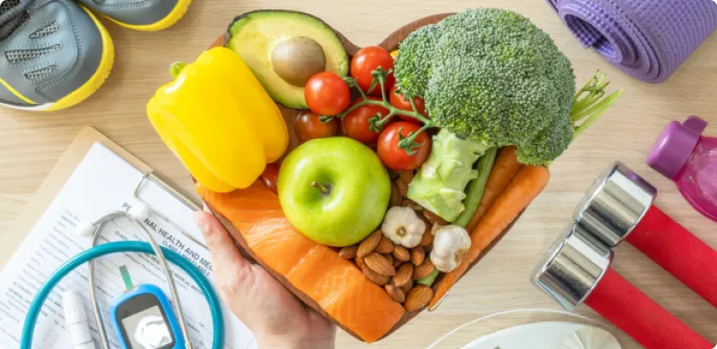 Overhead view of healthy food, a measuring tape, and exercise equipment, symbolizing holistic approaches to improving gut health, metabolic function, and overall wellness.