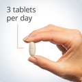 Hand holding a single tablet, highlighting a recommended dosage of three tablets per day for optimal bone health support.