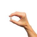 Woman’s hand holding Metagenics ImmuCore® tablet.
