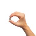 Woman’s hand holding Metagenics Andrographis Plus® tablet. 