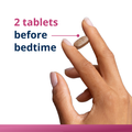 Dosage image showing two HerWellness Recharge Overnight tablets held between fingers, with on-screen text recommending 2 tablets before bedtime.