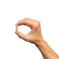 Hand holding a single Metagenics Thyrosol® capsule.