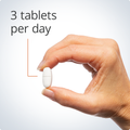 Hand holding a single tablet, highlighting a recommended dosage of three tablets per day for optimal bone health support.
