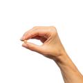 Woman’s hand holding Metagenics Milk Thistle Extract tablet.