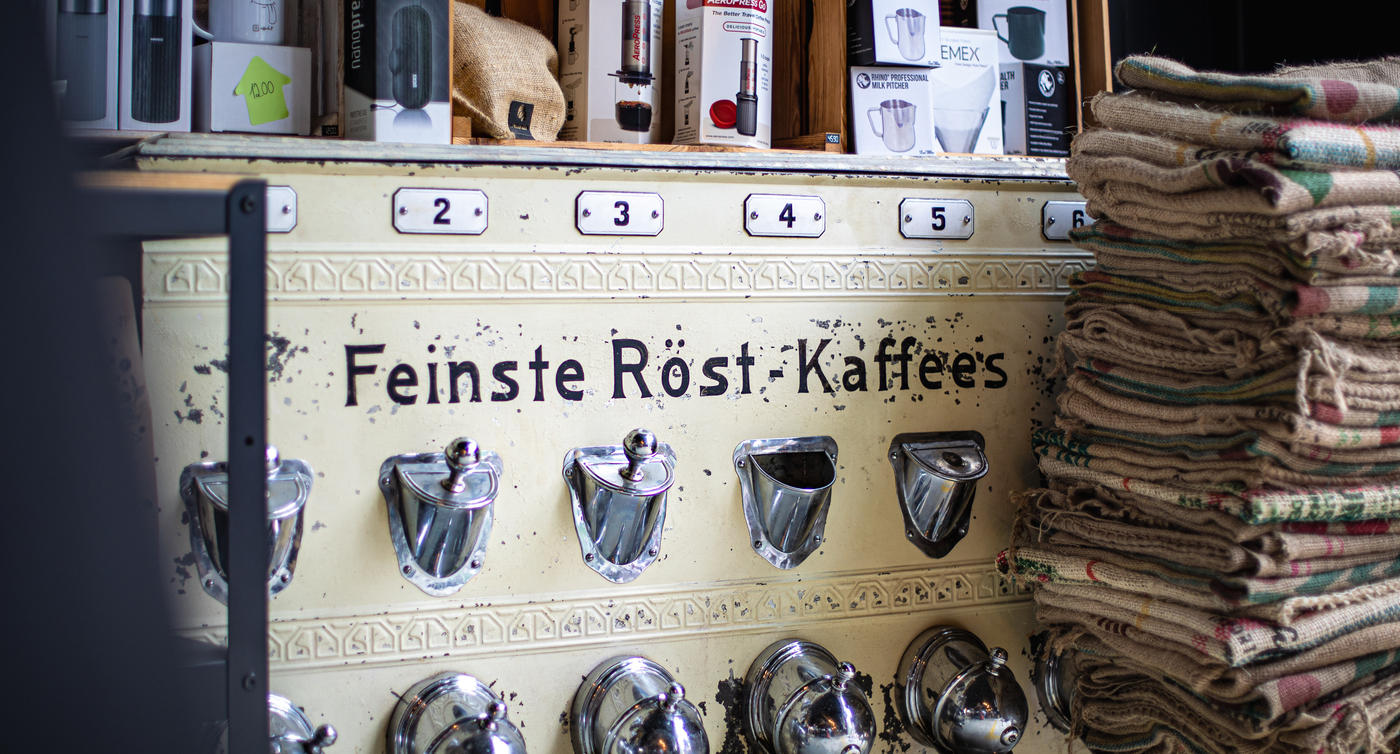 Ein antiker Schrank, wo einst Kaffee gelagert wurde. Darauf stehen neue Kaffee-Produkte zum Verkauf.