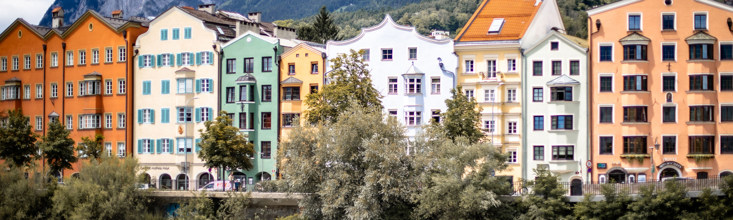 Des maisons colorées derrière une rivière.