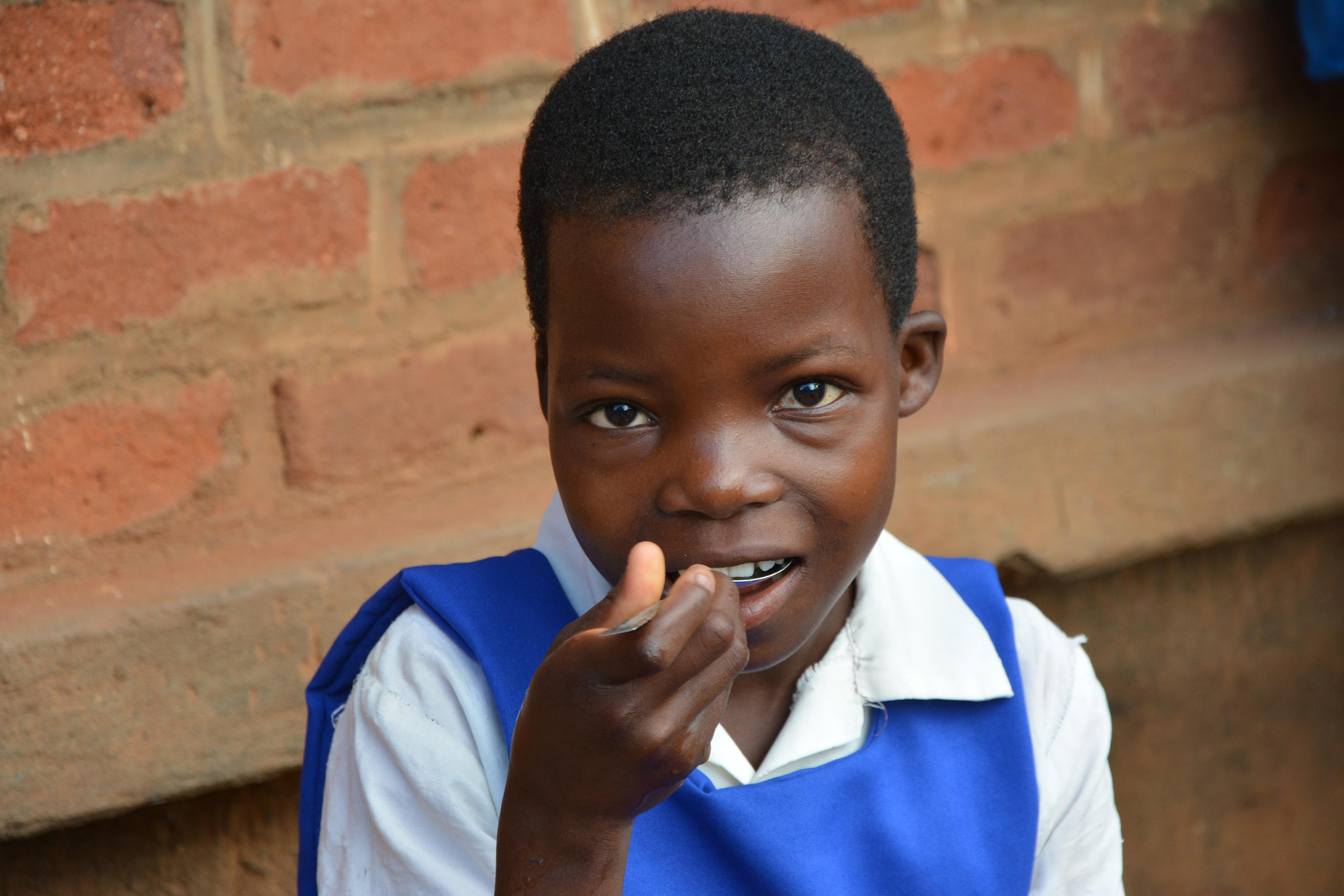 Schülerinnen und Schüler erhalten nach dem Unterricht in Salima, Malawi täglich eine gesunde Mahlzeit. (School feeding project) Das Programm wird vom Schweizerischen sowie vom Malawi Roten Kreuz unterstützt.