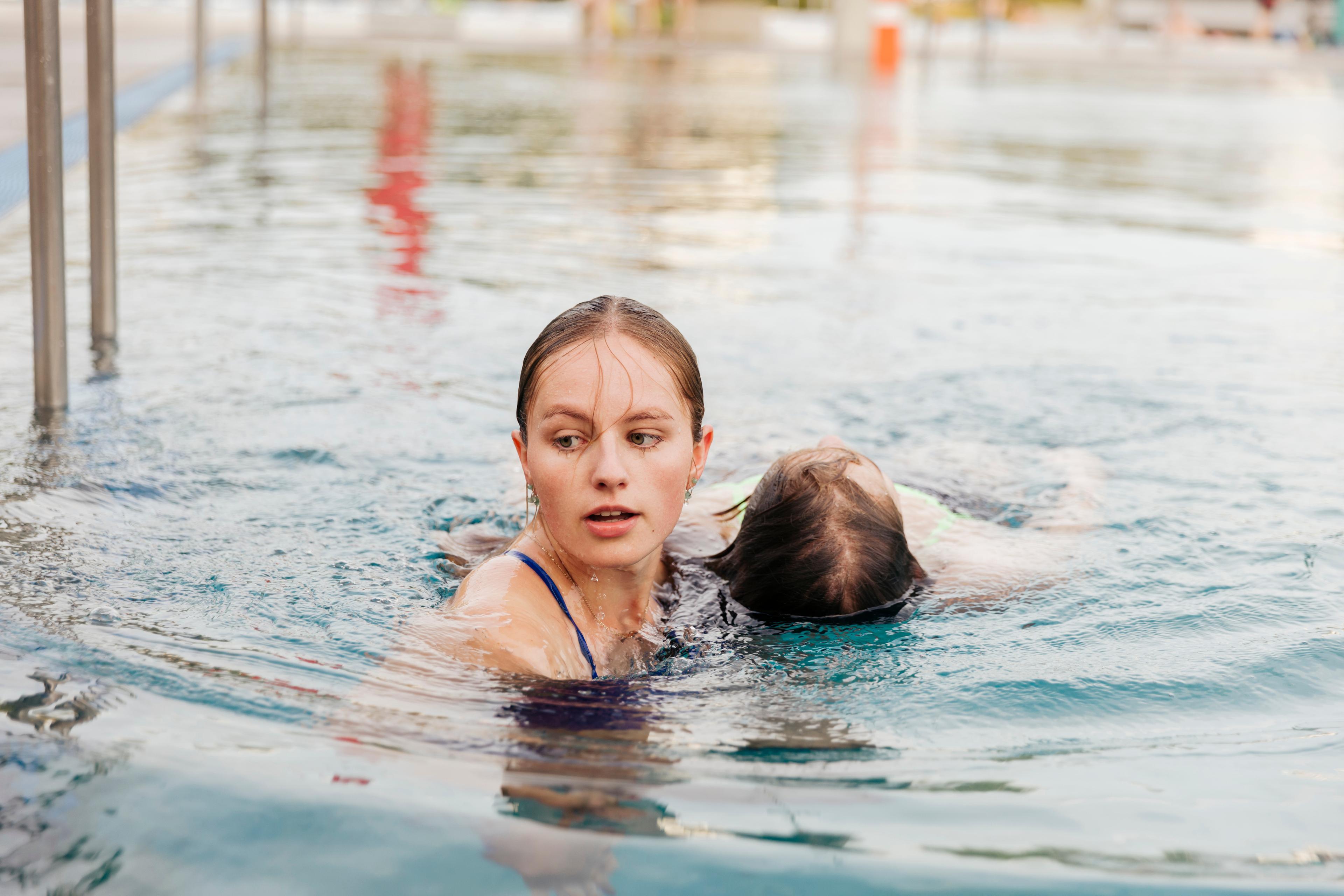 Eine junge Frau übt, im Wasser eine Person zu retten