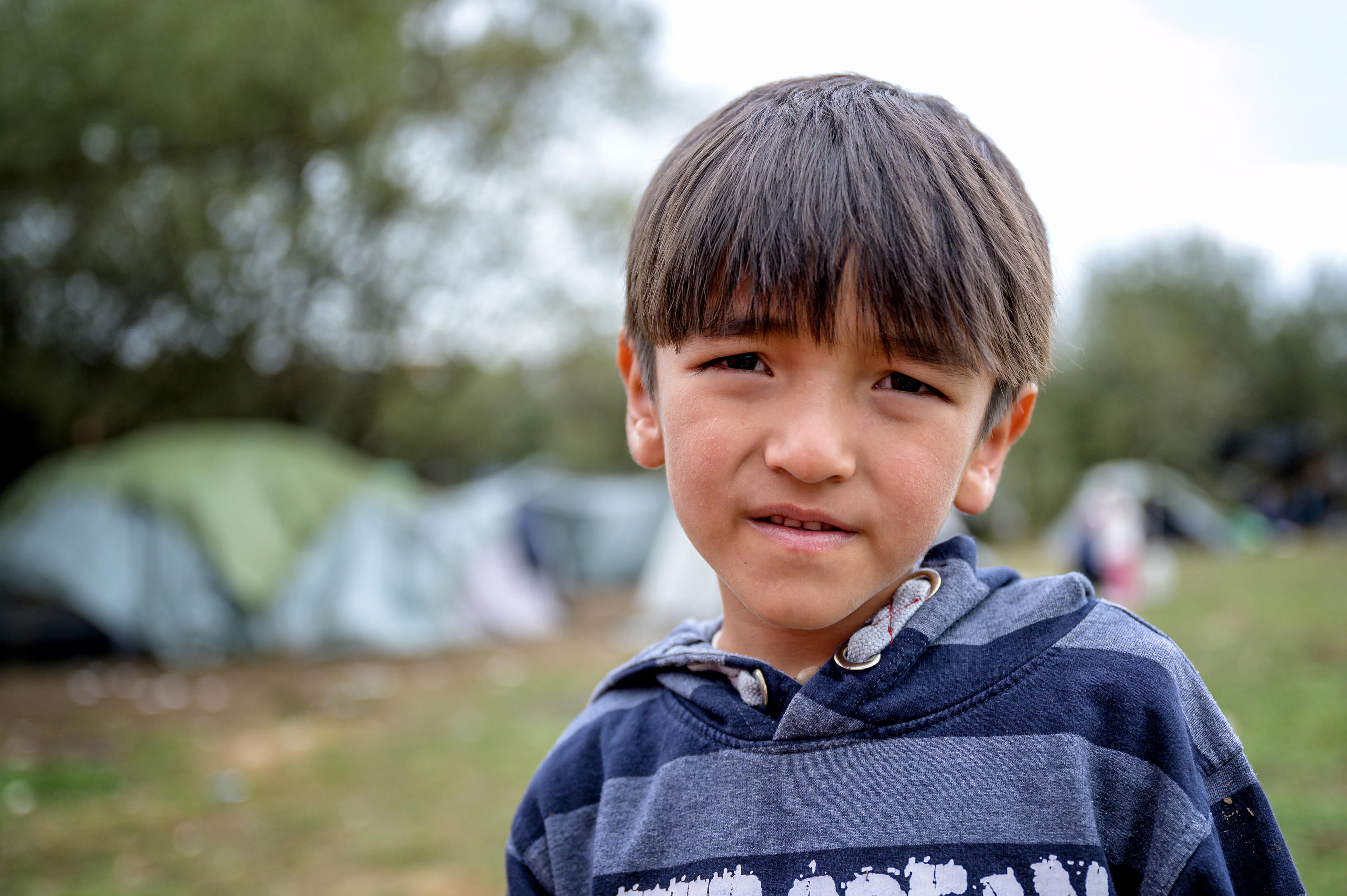 Un garçon devant un camp de tentes en Bosnie-Herzégovine.
