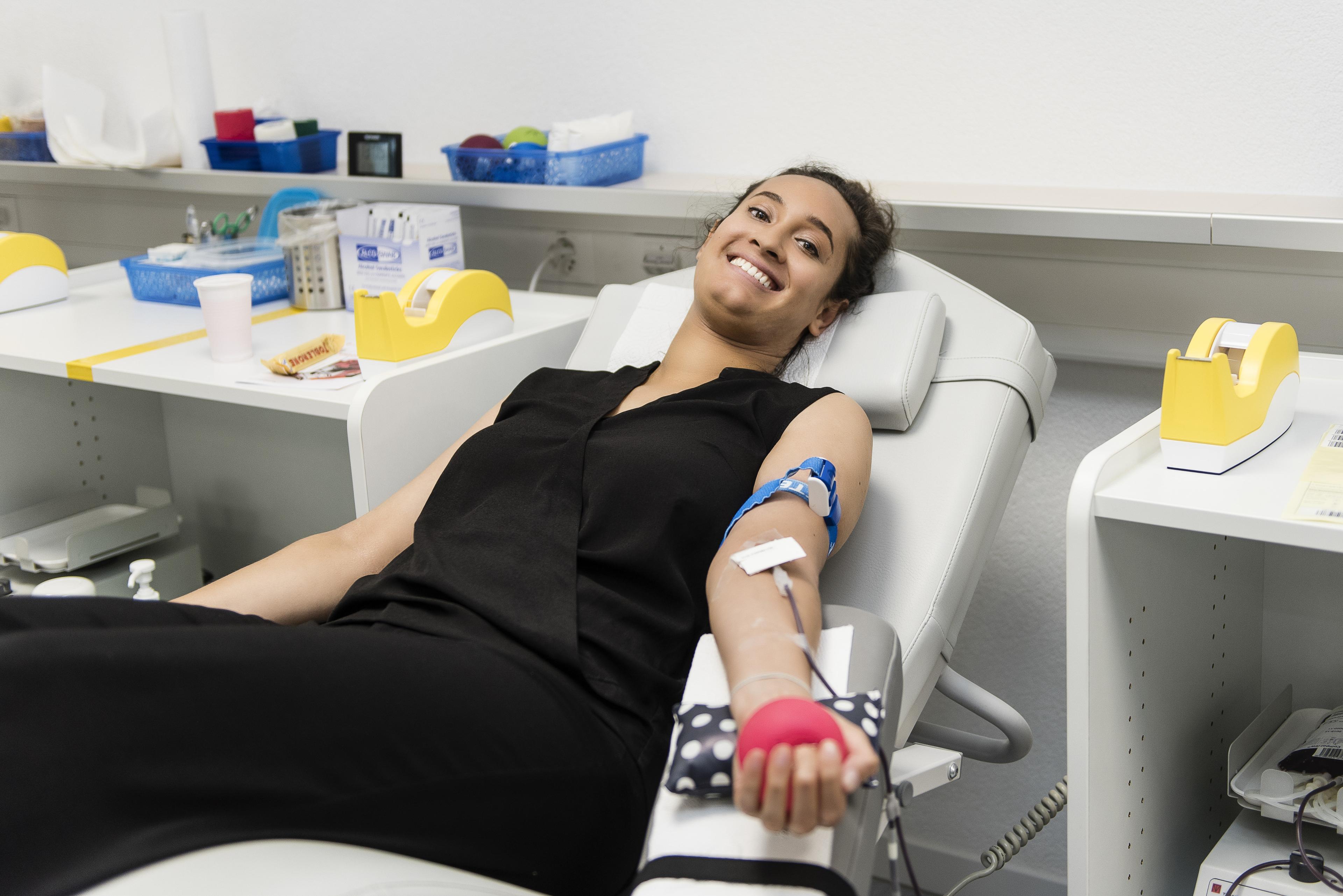 Una signora che dona il sangue, sdraiata su una poltrona reclinabile.