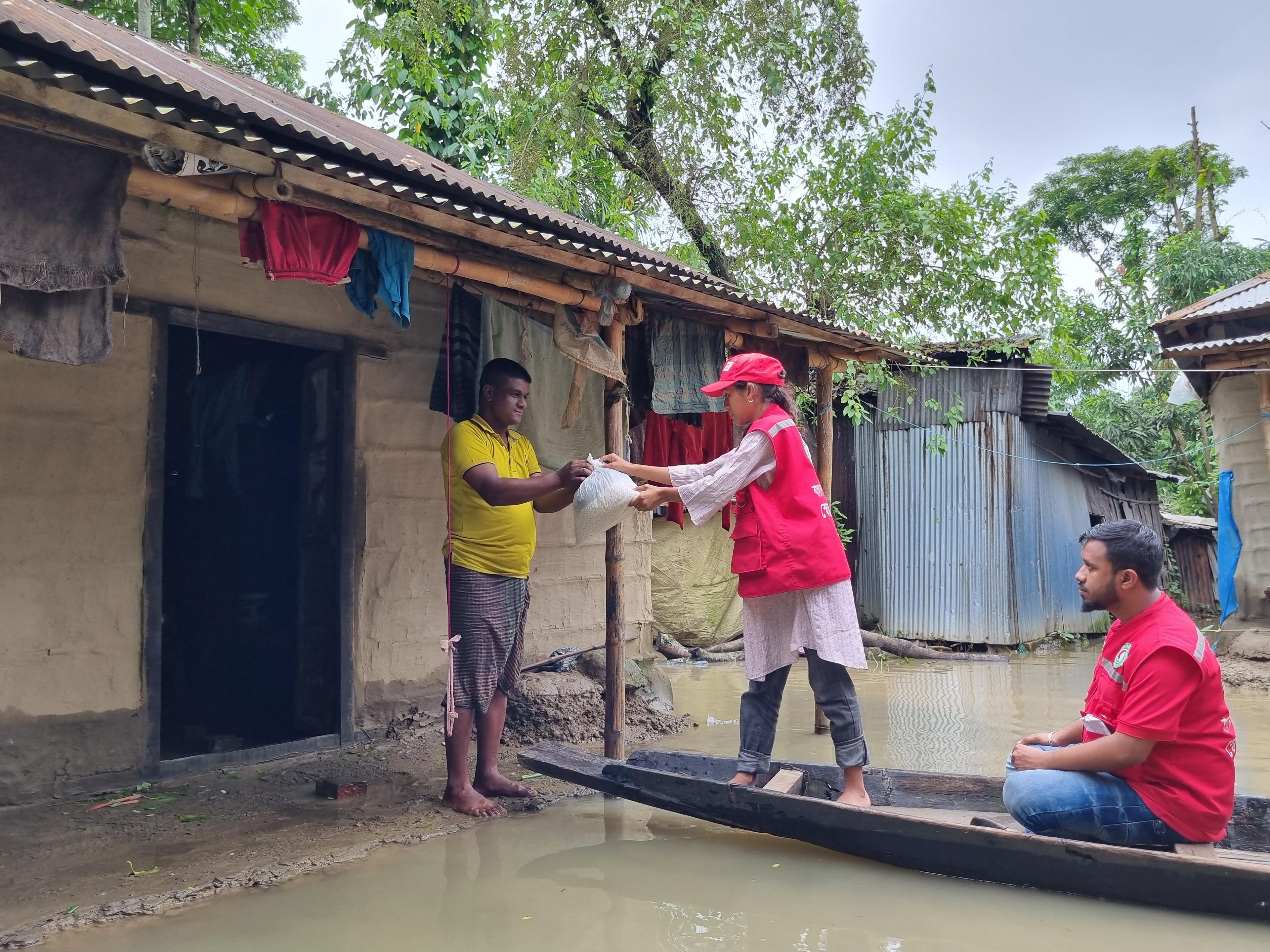 I volontari della Mezzaluna Rossa del Bangladesh consegnano cibo a un residente colpito dalle inondazioni, qui a Sylhet.