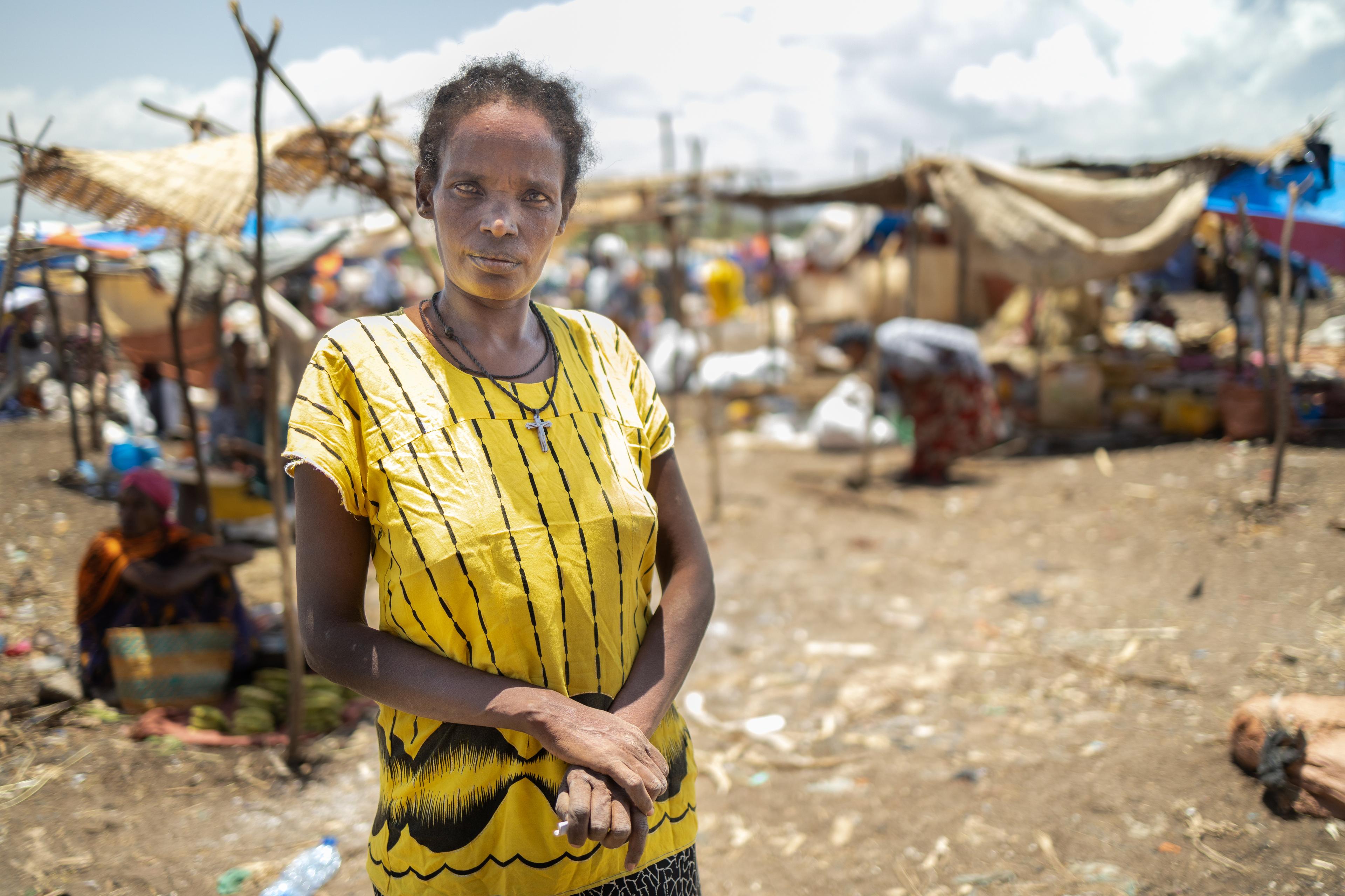 Una donna davanti al mercato distrutto da un incendio doloso durante il conflitto a Derashe, in Etiopia.