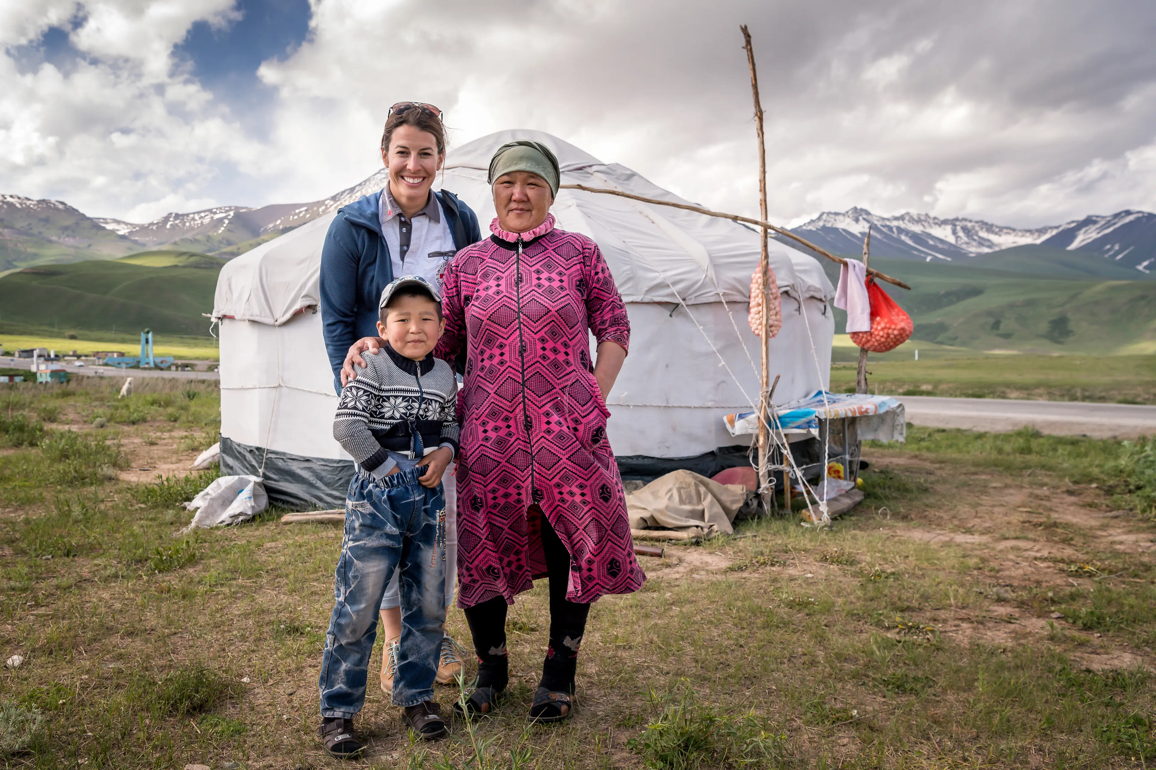 Dominique Gisin with mother and child of the shepherd family in front of a yurt.