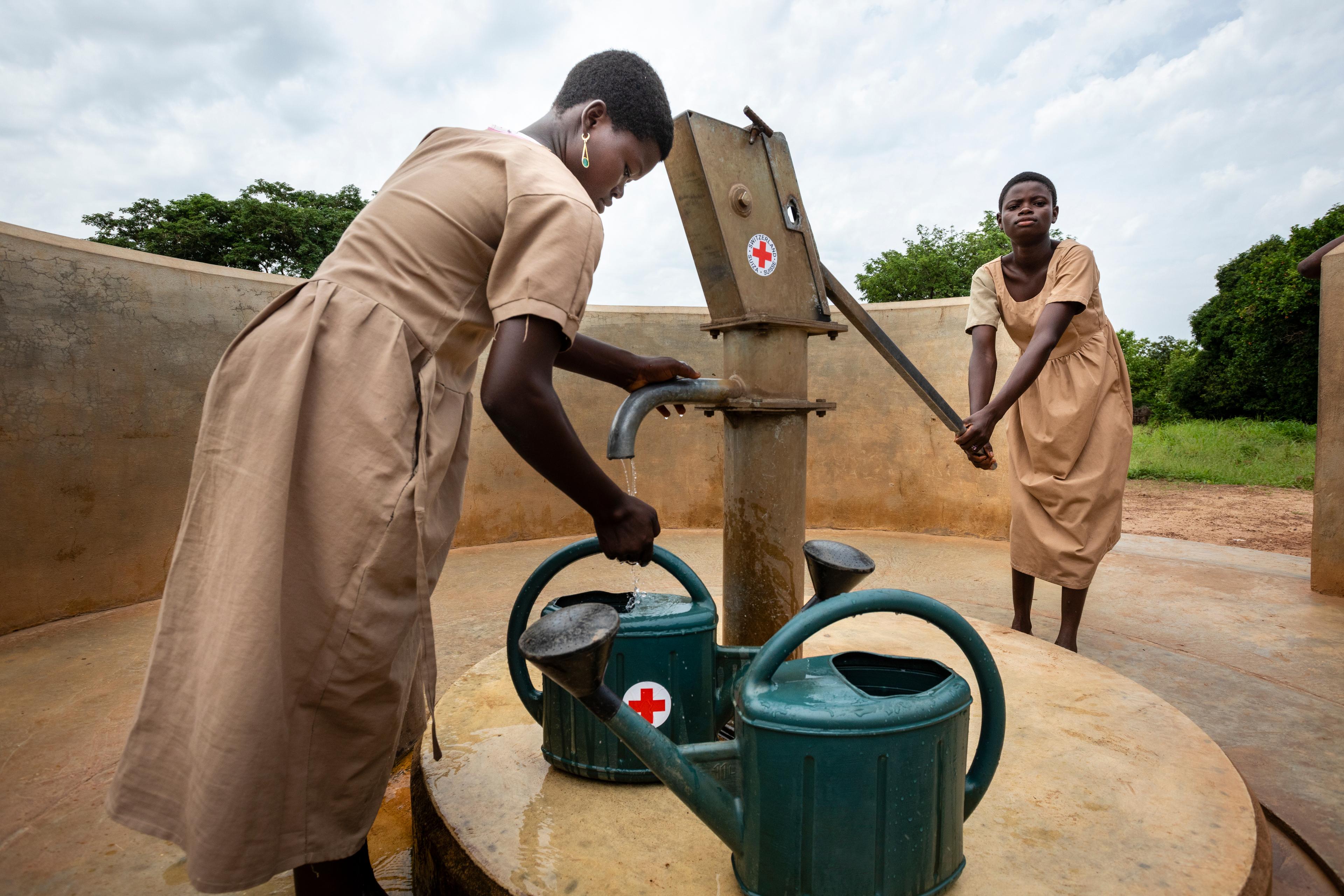 Au Togo, deux écolières de 12 ans s’approvisionnent au point d’eau construit par la Croix-Rouge suisse. L’eau, c’est la vie. Le parrainage pour l’accès à l’eau potable permet notamment l’aménagement de fontaines et de puits.