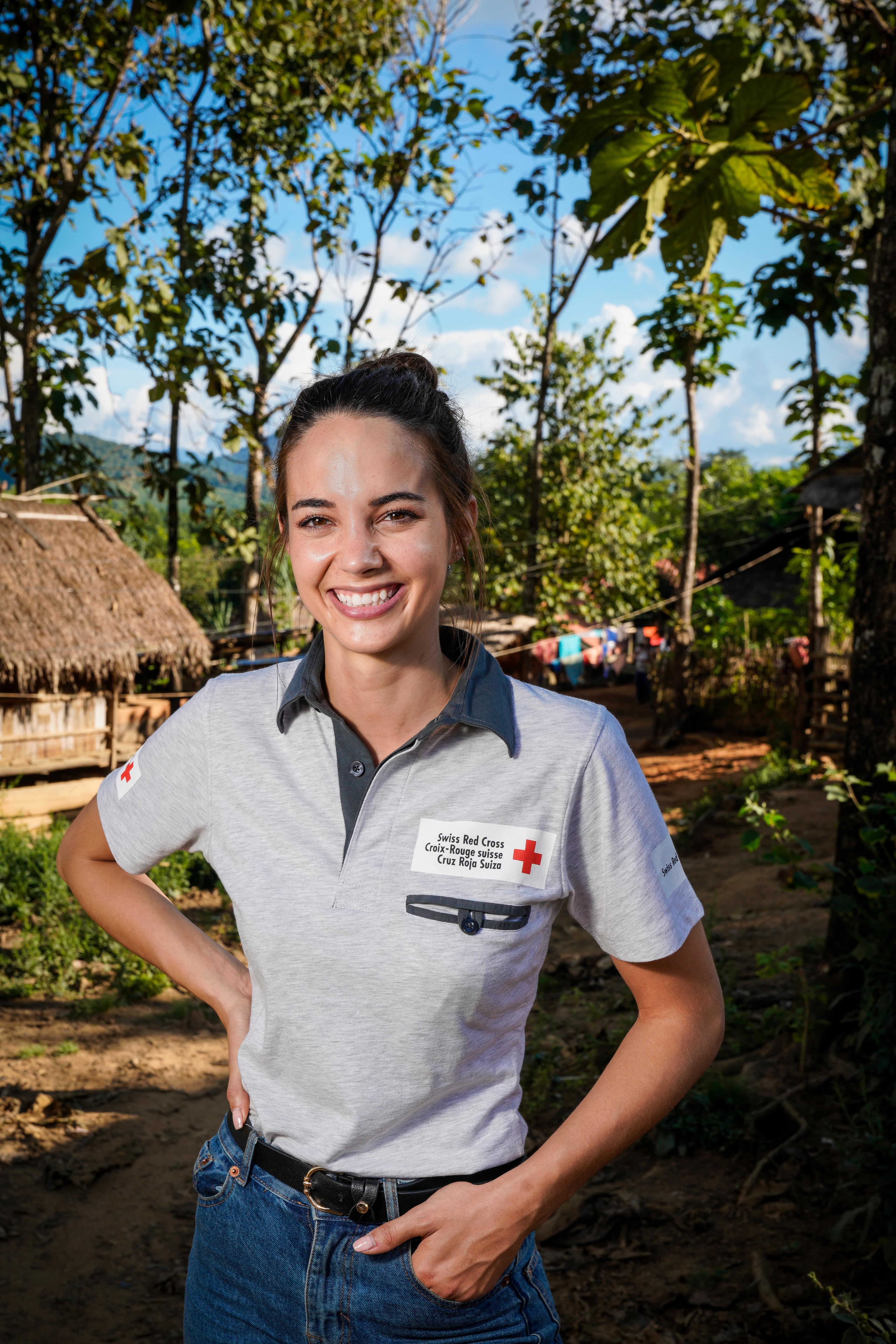Laetitia in front of a village in a polo shirt of the SRC.