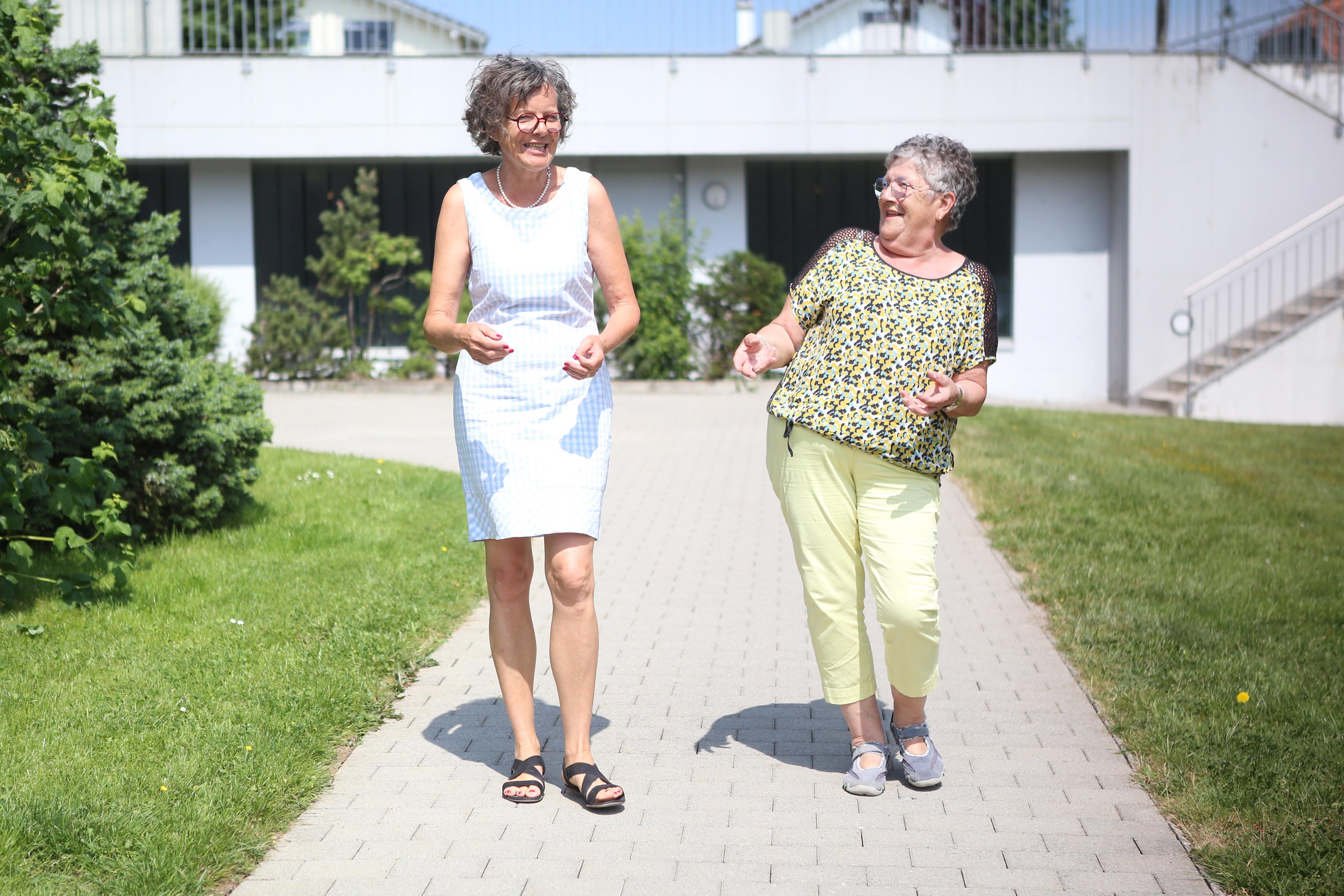 Martine Pipoz e Imelda Morard camminano insieme mentre chiacchierano. Entrambe sorridono.  
