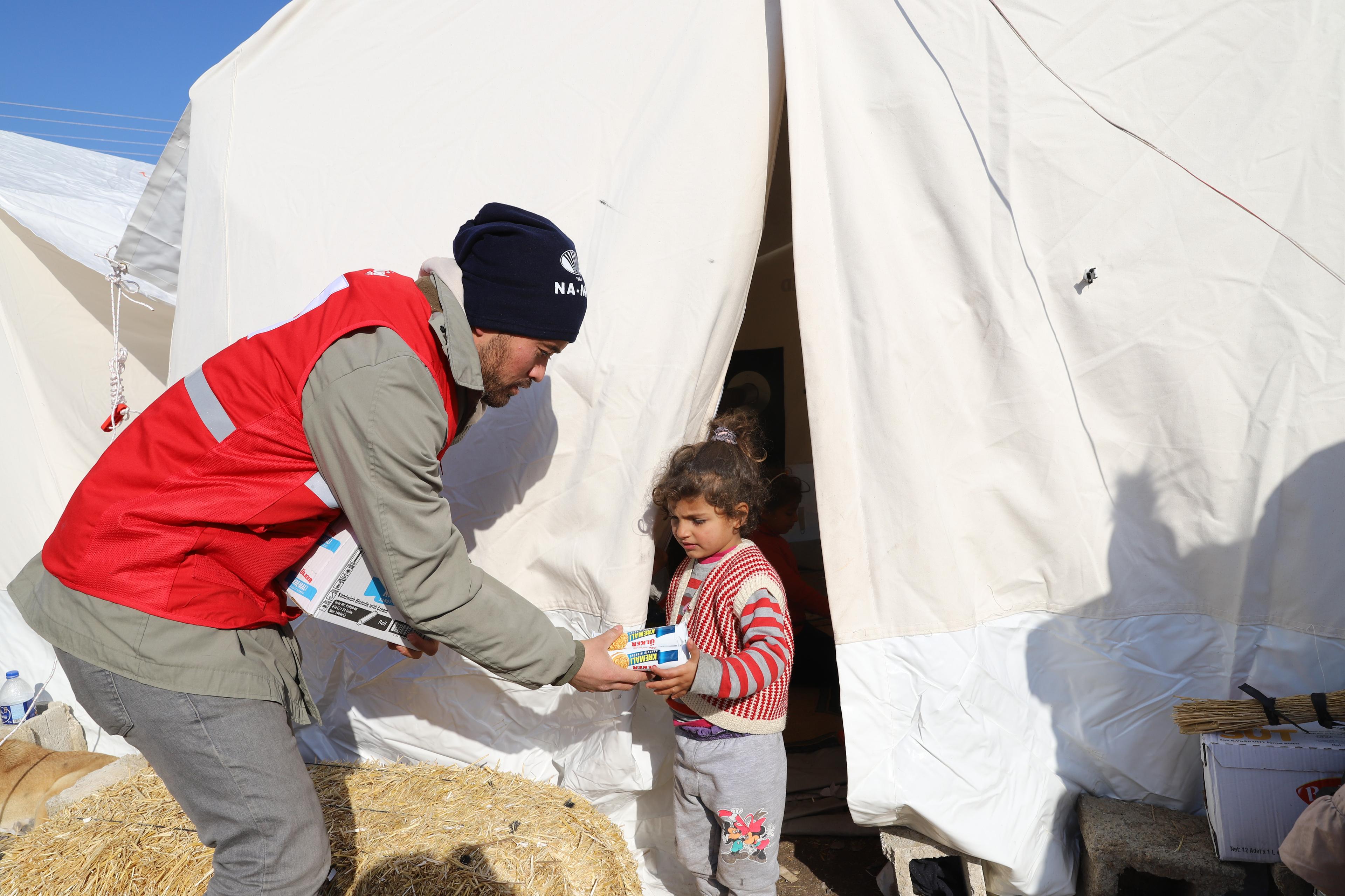 Turkish Red Crescent volunteers set up temporary shelters and distribute food to affected families. 