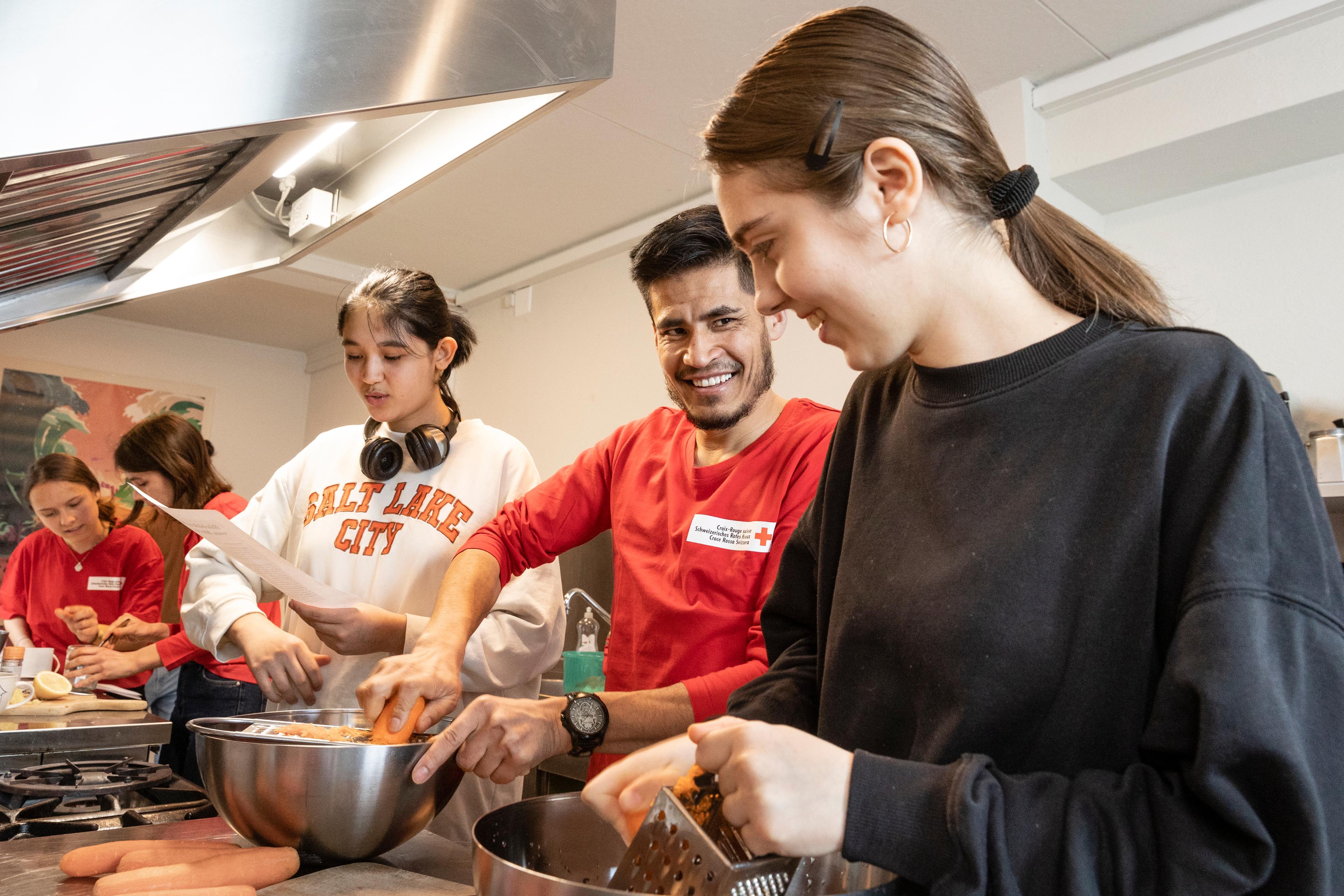 Marina Plesca, Roshan-Ali Akhondzadeh et Fatemeh Hosseini râpent les carottes nécessaires à la confection d’un gâteau. Ils sont réunis dans le cadre d’un projet d’intégration à bas seuil de la Croix-Rouge Jeunesse lucernoise.