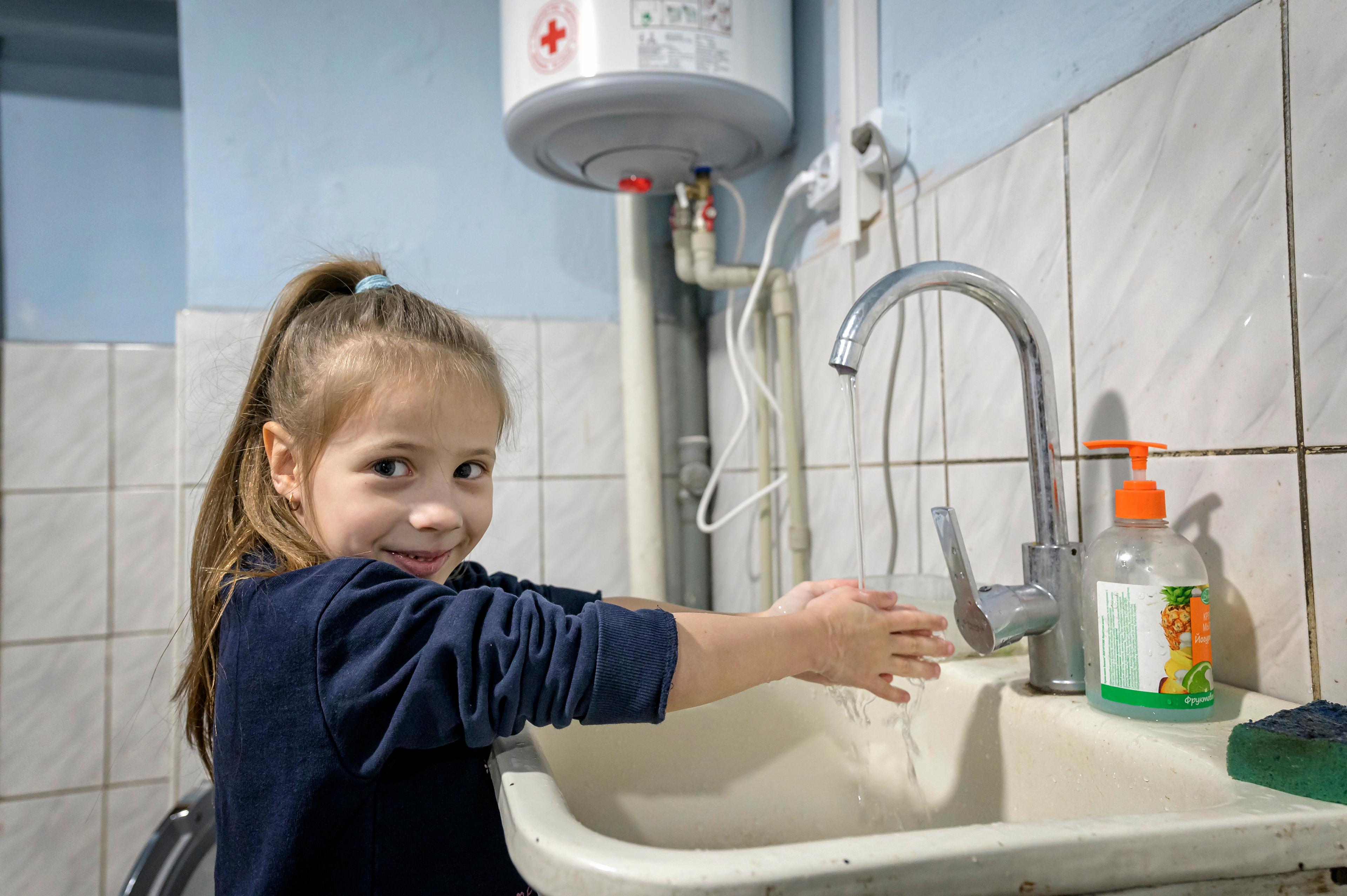 Elisabeta, six ans, se lave les mains dans un abri d'urgence dans l'ouest de l'Ukraine.